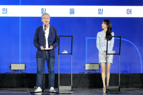 임죵룡 우리금융 회장이 17일 스페이셜 게스트 아이유와 함께 '우리 루키 프로젝트'에 대해 설명하고 있다.  [우리금융 제공]